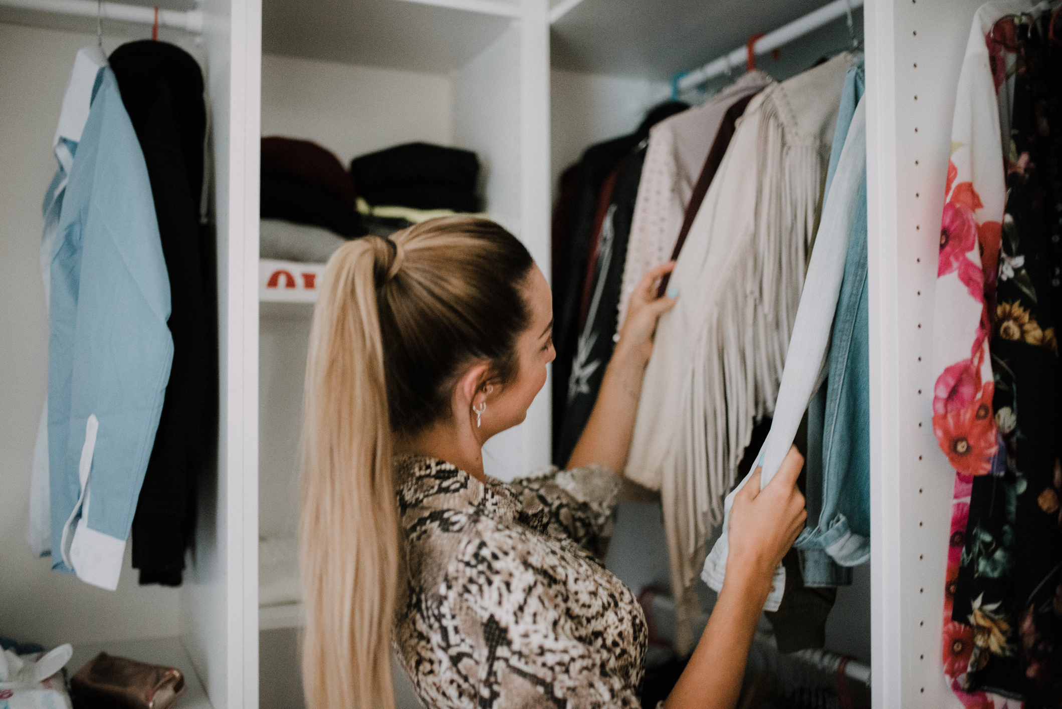 Young woman at wardrobe choosing what to wear
